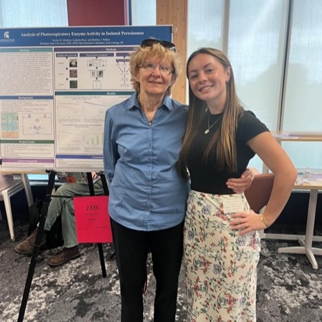 Two people stand in front of a scientific poster