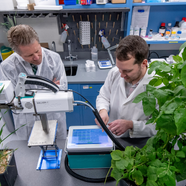 Berkley Walker (right) shows Michigan State University President Kevin Guskiewicz (left) around the lab. 