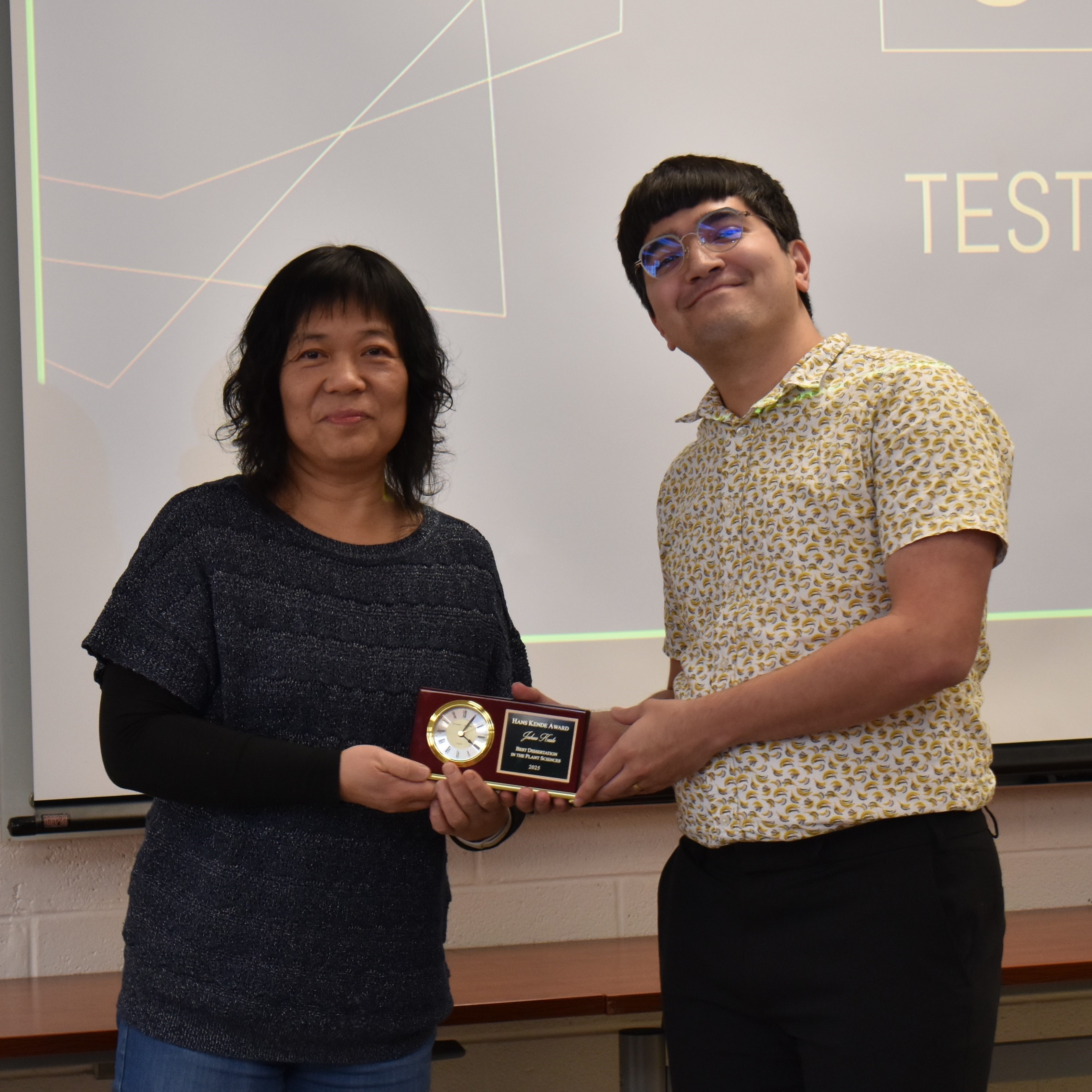 A person hands another person an award