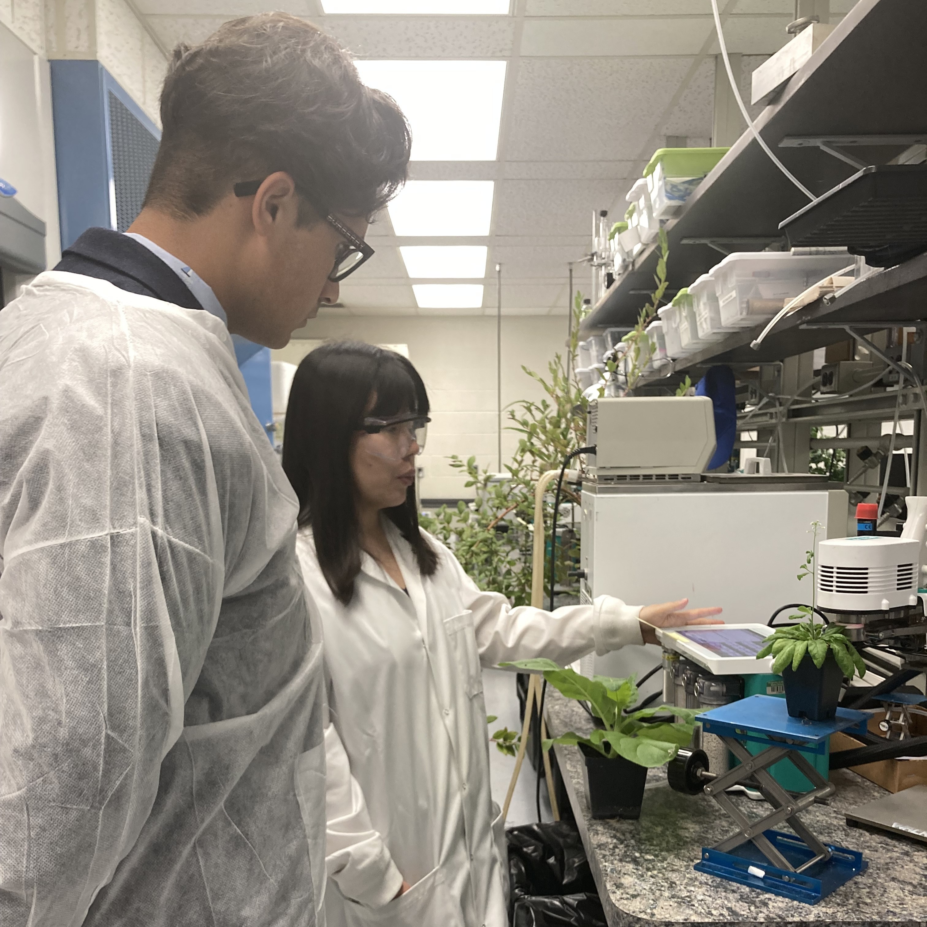 Two people in lab coats discuss research